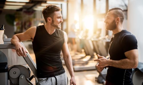 Two men chatting in a gym